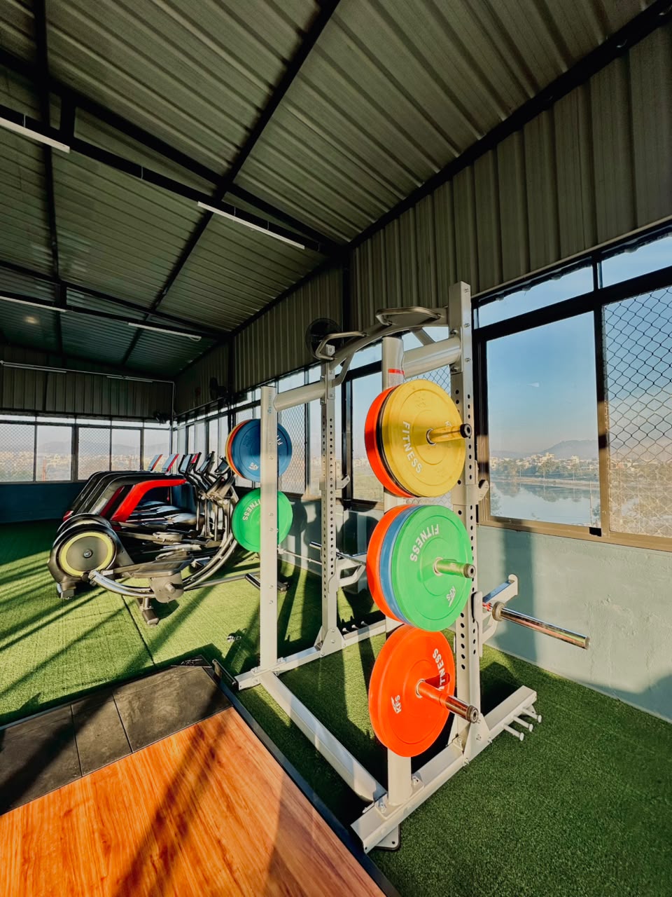 Rooftop training floor with squat racks and cardio machines at EKAAY Fitness