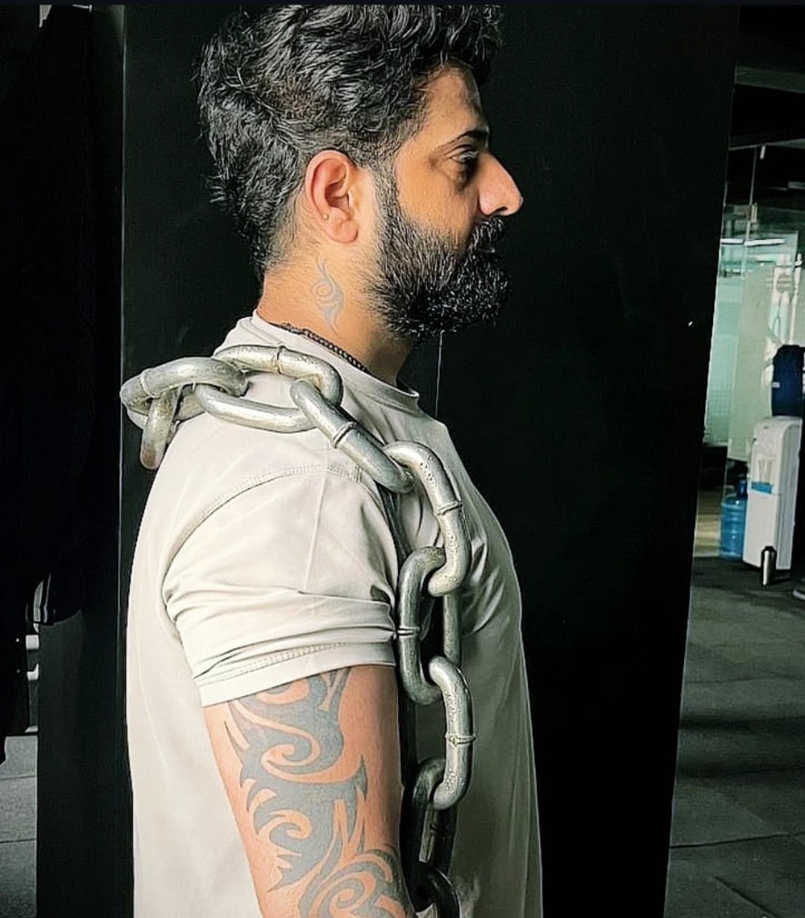 Vinod Gurjar carrying heavy chains on the training floor